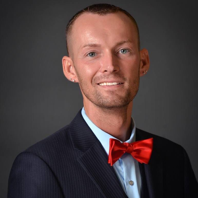 Chris Noble in dark blue suit and red bowtie