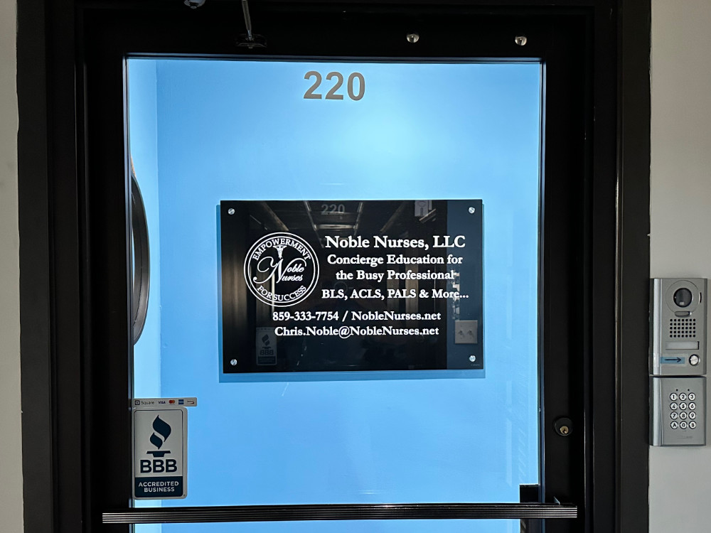 A photo of the office door at Noble Nurses. The door is brown with clear glass. The glass has the Noble Nurses logo.
